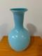 Light blue or turquoise blown glass vase with a globe-shaped base and a narrow n