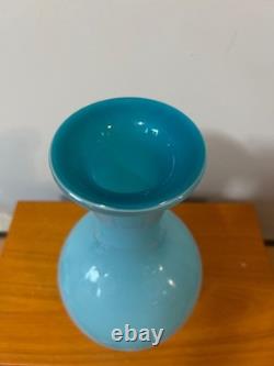 Light blue or turquoise blown glass vase with a globe-shaped base and a narrow n