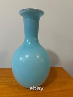 Light blue or turquoise blown glass vase with a globe-shaped base and a narrow n